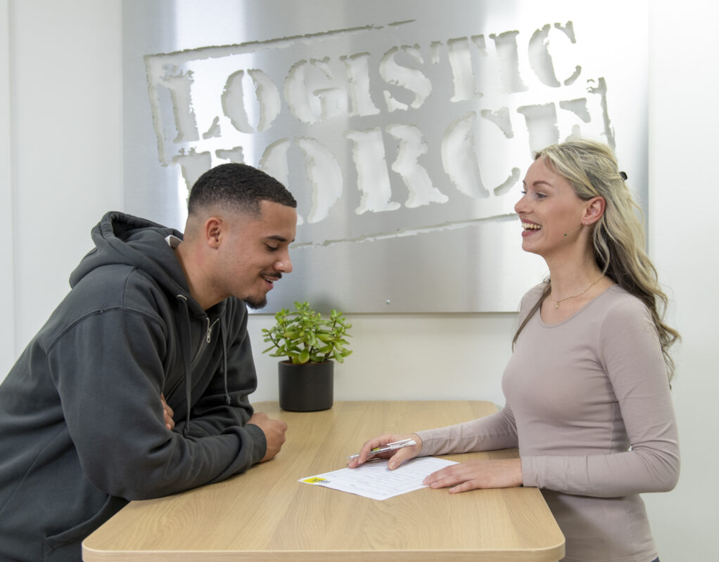 Man en vrouw lachend aan tafel bij Logistic Force