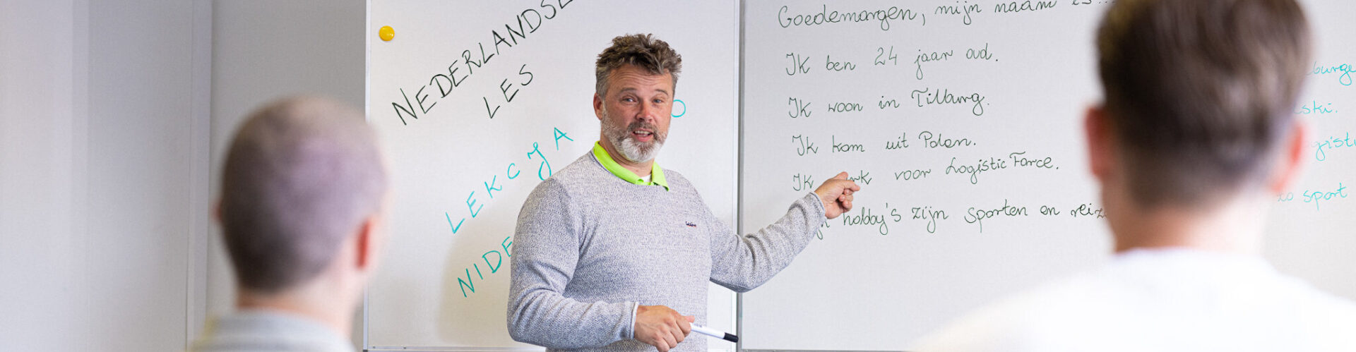 Docent geeft Nederlandse taal les aan 2 mannen